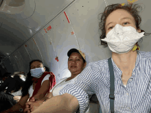 a woman wearing a 3m n95 mask is sitting on an airplane