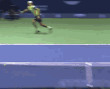 a tennis player in a yellow shirt is running on the court