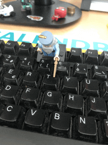 a lego figure is standing on a keyboard with the letter t on it