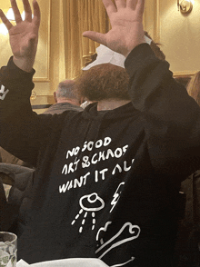 a man wearing a hoodie that says " no good art & chaos want it all "