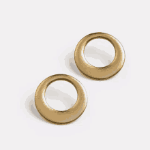 a pair of gold stud earrings with a circle in the middle