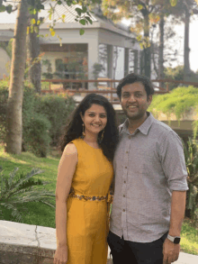 a man and a woman pose for a picture in front of a building