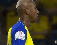 a man in a blue and yellow jersey has a patch on his arm that says ' spizza '