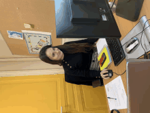 a woman is sitting at a desk with a dell computer