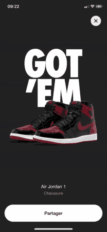 a phone screen shows a pair of nike air jordan 1 shoes