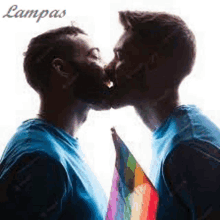 two men are kissing with a rainbow flag between them .