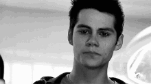 a black and white photo of a young man 's face with a tv logo in the background .