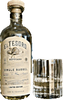 a bottle of el tesoro reposado single barrel tequila next to a glass