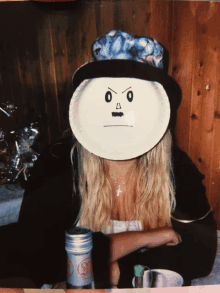 a woman wearing a hat and a paper plate on her face with an angry face drawn on it