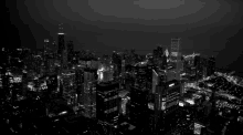 a black and white photo of a city at night with a sign that says ' chicago '