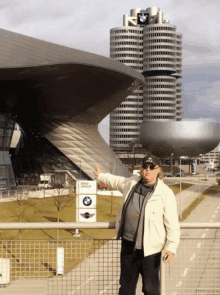 a man standing in front of a bmw sign