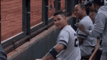 a group of baseball players are sitting in the dugout and one of them has the number 2 on his shirt