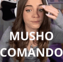 a woman wearing headphones with the words musho comando on the bottom of her face .