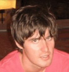 a close up of a man 's face wearing a red shirt .