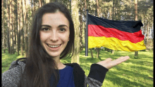 a woman is holding a small german flag in her hand