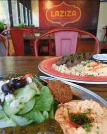 two plates of food on a table in front of a laziza restaurant