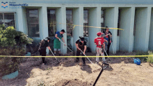 a group of people are digging in front of a building that says mapochorio