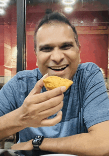 a man wearing a watch that says keep smiling while holding a piece of food