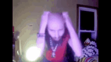 a man with a beard is holding his head in a room with purple lights behind him