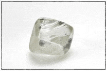 a close up of a diamond on a white surface with a frame around it .