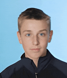 a young boy with blue eyes and a black jacket