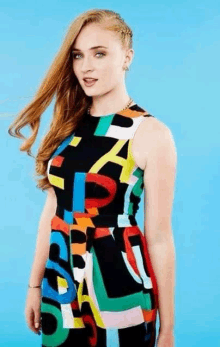 a woman is wearing a colorful dress with letters on it .