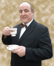 a man in a suit and bow tie is holding a cup of coffee