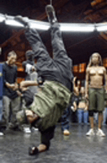 a man is doing a handstand on a dance floor