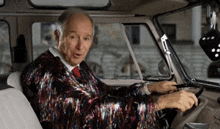 a man in a sequined jacket is sitting in a car