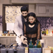 a man and a woman are in a kitchen preparing food together