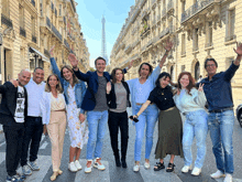 a group of people standing on a street with their arms in the air