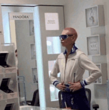 a man wearing sunglasses stands in front of a sign that says pandora