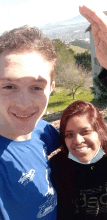 a man and a woman are posing for a picture and the man is wearing a blue shirt that says ' jeep '