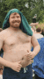 a shirtless man with a green towel on his head