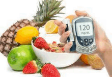 a person is holding a glucose meter in front of a bowl of fruit .