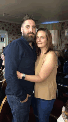 a man with a beard is hugging a woman