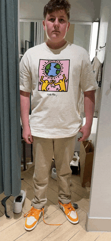 a boy wearing a t-shirt with a picture of a man holding a globe