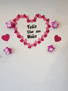 a white wall with a heart made out of hearts and the words feliz dia das maes