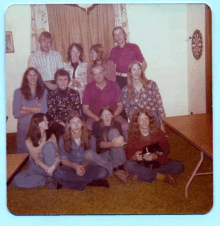 a group of people are posing for a picture in a room with a dart board in the background