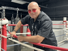 a man in a boxing ring wearing red sunglasses