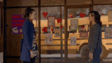 two women standing in front of a school bus with a sign that says have found a date on it