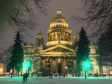 a large building is lit up at night with a dome