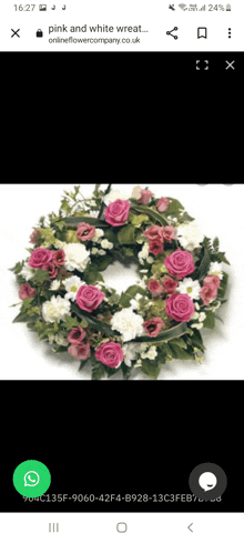 a wreath with pink and white flowers is displayed on a phone screen