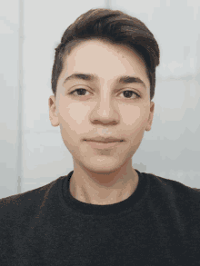 a close up of a young man 's face wearing a black shirt