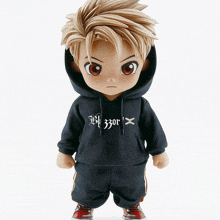 a figurine of a boy wearing a black hoodie with the letter x on the front