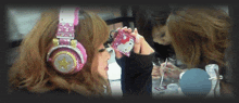 a woman wearing hello kitty headphones looks at herself in a mirror