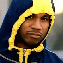 a man wearing a blue and yellow hooded jacket