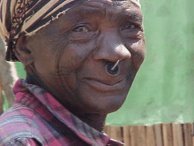 a close up of a man with a nose ring and a bandana on his head