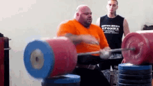 a man lifting a barbell with a shirt that says kronhx