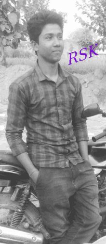 a young man sitting on a motorcycle with rsk written on the bottom of the photo